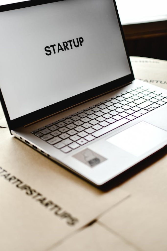 photo-of-a-laptop-6956451 Modern laptop with startup text on screen, ideal for business themes.